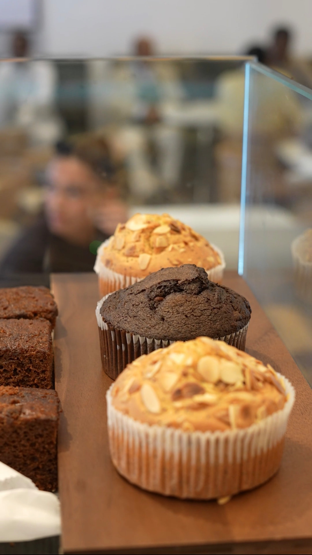 Almond and chocolate muffins in the counter display case