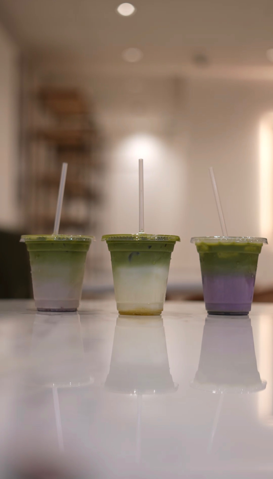 Three layered ombré matcha lattes on a marble table at MAICAFE in Shepherd's Bush